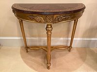 Front angled view showing half-moon top, carved apron, legs, stretcher