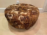 Overall view of upholstered round ottoman showing top and sides