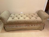 Full view of bench showing tufted seat, rolled arms, tassel fringe