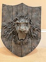Front view of lion head plaque on shield backing