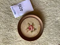 Front view of round framed embroidered rose
