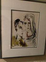 Framed portrait artwork showing two female figures, mat and frame visible