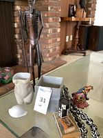 Overall lot on glass table showing statue, beads, vase, figurine, books, match holder, planter