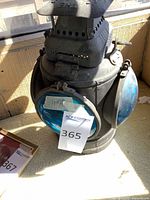 Front view of metal maritime lantern with blue lens