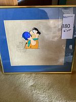 Framed animation cel showing Fred Flintstone with bowling ball, blue mat, gold frame, lot tag visible