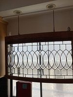 Full view of curved leaded glass panel hanging in window opening