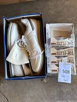 Shoes in original box beside three sealed Spalding Top-Flite Plus golf ball boxes