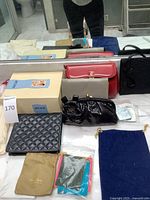 Group shot of all items including boxed breast form, three handbags, quilted pouch and jewelry pouches