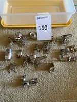 Group of silver-tone metal miniatures laid out on carpet