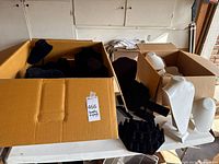 Two boxes holding black velvet and white faux-leather necklace bust stands with a black ring holder in front