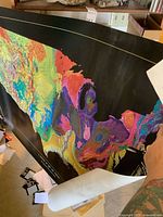 Overall view of colorful USGS terrain map poster partially unrolled