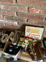 Overview of scarves, belts in box, suspenders and framed backing