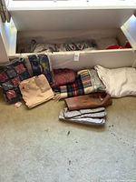 Overview of all folded textiles on floor and in drawer