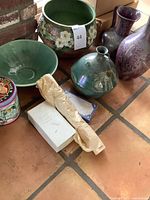 Group shot showing planter, bowl, tin, box, wrapped item, jug vase and purple vases
