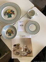 Front view of dinner plate, bowl, mug, saucer and brochure