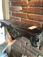 Full view of shelf mounted on brick wall showing size and design