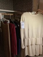 Ivory knit suit top and skirt on hanger