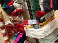 Assorted clothing, sneakers, gloves, sandals, striped pole, medal visible