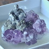 Overall view of amethyst cluster with pewter miner figurine