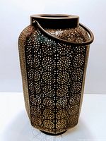 Full view of perforated metal lantern with floral design and handle