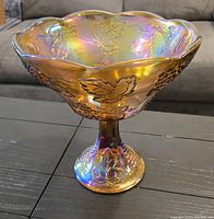 Side view of amber iridescent carnival glass pedestal compote dish