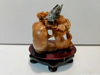 full view of multicolored jade sculpture on wood base