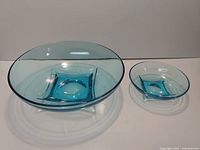 Both blue glass bowls side by side showing size difference and design