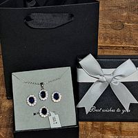 Boxed jewelry set showing necklace, earrings, ring and packaging