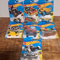 All seven sealed Hot Wheels cards displayed on tabletop