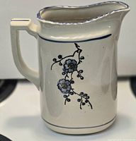Front quarter view showing floral motif, handle, spout