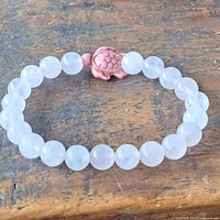 Full view of bracelet showing rose quartz beads and turtle charm