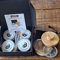 Full kit inside box showing tins, spoon, smoker lid, screens, pouch, and manual