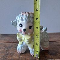 Full view of porcelain lamb planter with tape measure showing approx 6 inch height