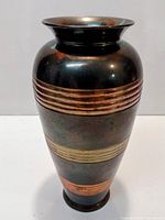 Full view of metal vase with accent bands