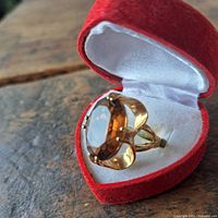 Ring in open red heart box showing side profile of gold setting and gemstone