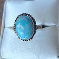 Front view of the ring displaying larimar cabochon and twisted rope bezel