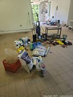 Wide view of lot showing power washer, bags of repair material and garden rock.