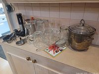 Overview of all bar and pub collectible items together on countertop including bottles, glasses, opener, and ice bucket