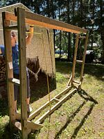 Front and side view of the homemade firewood holder frame outdoors with measurement acting as reference.