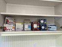 Wide view of multiple boxes of LED light bulbs arranged on a white shelf showing brands Cree LED, Relax and other assorted bulbs