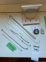 Full lot overview including all chains, rhinestone jewelry set in box, two brooches and bracelet