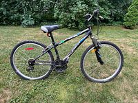 Full side view of the black HT 26 Sportek mountain bike showing frame, tires, seat, handlebars, and gears.