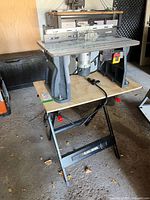 Front view of Kobalt router table and Black & Decker Workmate setup on garage floor.