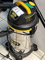 Full view of Stanley wet dry vacuum including stainless steel tank, black and yellow motor housing, and power cord.