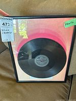 Framed record with visible black frame and 15x12 size label on the glass.