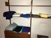 Fabric pieces folded and stacked on shelves, showing various colors and textures.