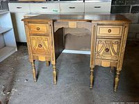 Front view showing two small upper drawers, two larger carved lower drawers and turned front legs.