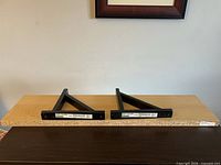 Shelf top view with two black L-brackets resting on it