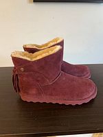 Side view of both burgundy suede ankle boots