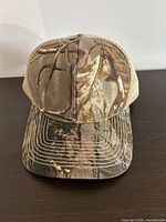 Front view showing camo pattern, Volvo logo, curved brim